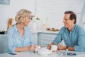 happy senior couple smiling each other and talking while drinking tea together at home Royalty Free Stock Photo