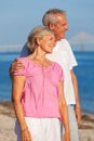 Happy Senior Couple Standing Embracing on a Beach Royalty Free Stock Photo