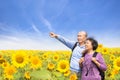 Happy senior couple standing in the sunflower garden