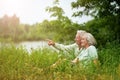 Happy senior couple in summer park. man pointing with finger Royalty Free Stock Photo