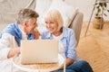 Happy senior couple surfing net on laptop at home Royalty Free Stock Photo