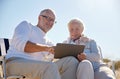 Happy senior couple with tablet pc on summer beach