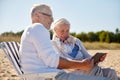 Happy senior couple with tablet pc on summer beach Royalty Free Stock Photo