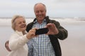 Happy senior couple taking selfie with mobile phone at the beach Royalty Free Stock Photo