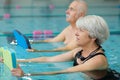 happy senior couple taking swimming lessons