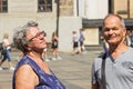 Happy senior couple tourists walking at Prague Castle square. Smiling aged married traveling in summer vacations.