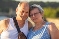 Happy senior couple tourists walking on streets of Prague old town. Smiling aged married traveling in summer vacations..