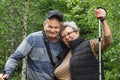 Happy senior couple tourists walking with trekking sticks in the mountain forest. Active seniors concept. Healthy life Royalty Free Stock Photo