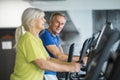 Happy senior couple training on stair stepper at gym Royalty Free Stock Photo