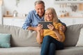 Happy Senior Couple Using Digital Tablet Browsing Internet At Home Royalty Free Stock Photo