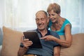 Happy senior couple using digital tablet at home Royalty Free Stock Photo