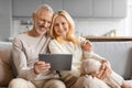 Happy Senior Couple Using Digital Tablet Together Browsing Internet Royalty Free Stock Photo