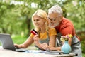Happy Senior Couple Using Laptop And Credit Card Outdoors For Online Shopping Royalty Free Stock Photo