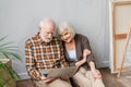 Senior couple using laptop sitting on Royalty Free Stock Photo