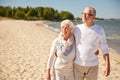 Happy senior couple walking along summer beach Royalty Free Stock Photo