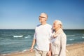 Happy senior couple walking along summer beach Royalty Free Stock Photo