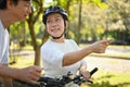 Happy senior couple walking with bicycle talking at summer city park. Retirement lifestyle concept. Royalty Free Stock Photo