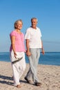 Happy Senior Couple Walking Holding Hands on a Beach Royalty Free Stock Photo