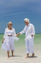 Happy Senior Couple Walking Holding Hands On Beach Royalty Free Stock Photo