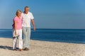 Happy Senior Couple Walking Laughing on a Beach Royalty Free Stock Photo