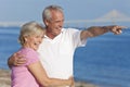 Happy Senior Couple Walking Pointing on Beach Royalty Free Stock Photo