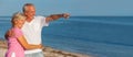 Happy Senior Couple Walking Pointing on a Tropical Beach Royalty Free Stock Photo