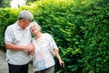 Happy senior couple walking together in the garden. Old elderly using a walking stick to help walk balance. Concept of  Love and Royalty Free Stock Photo