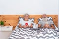 Happy senior couple watching videos with mobile phones while laughing together - Mature people having fun using smartphones at Royalty Free Stock Photo