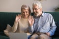 Happy senior couple waving hands doing online video chat Royalty Free Stock Photo