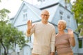 Happy senior couple waving hands over living house Royalty Free Stock Photo