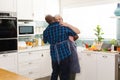 Happy senior diverse couple wearing aprons and dancing in kitchen Royalty Free Stock Photo