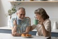 Happy senior family couple eating bakery food for breakfast Royalty Free Stock Photo