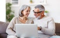 Happy senior family couple watching comedy or funny video on laptop while spending free time at home Royalty Free Stock Photo