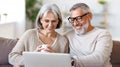 Happy senior family couple watching comedy or funny video on laptop while spending free time at home Royalty Free Stock Photo