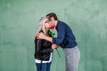 Happy senior family portrait. Handsome elderly bearded man giving beautiful red fresh rose to his charming smiling wife Royalty Free Stock Photo