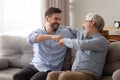 Happy senior father embracing young son giving fist bump