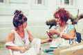 Happy senior female friends talking and drinking coffee  in a outdoor cafe Royalty Free Stock Photo