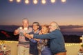 Happy senior friends celebrating birthday with sparklers stars outdoor - Older people having fun in terrace in the summer nights