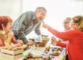 Happy senior friends having barbecue lunch at home - Old people having fun eating tasty meat skewers at bbq meal - Joyful elderly Royalty Free Stock Photo