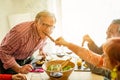 Happy senior friends having barbecue lunch at home - Old people having fun eating tasty meat skewers at bbq meal - Joyful elderly Royalty Free Stock Photo