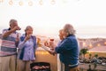 Happy senior friends having doing barbecue party on patio - Retired people having fun drinking wine and grilling meat at bbq