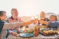 Happy senior friends having fun cheering with red wine at barbecue in terrace outdoor - Mature people making dinner Royalty Free Stock Photo