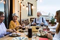 Happy senior friends having fun dining together on house patio Royalty Free Stock Photo