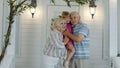 Happy senior grandfather and grandmother couple holding granddaughter in hands in porch at home Royalty Free Stock Photo