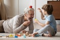 Happy senior grandfather play with small grandson