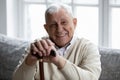 Happy senior grandfather sitting on couch smiling demonstrating healthy teeth