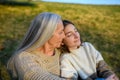 Happy senior grandmother with teenage granddaguhter hugging in nature on spring day. Royalty Free Stock Photo