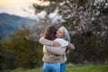 Happy senior grandmother with teenage granddaguhter hugging in nature on spring day. Royalty Free Stock Photo