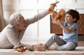 Happy mature grandparent playing with little grandson at home Royalty Free Stock Photo