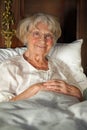 Happy senior lady relaxing in bed Royalty Free Stock Photo